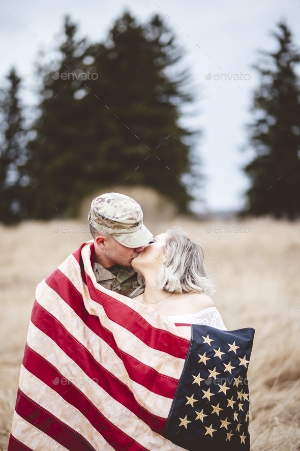Shallow focus vertical shot of an American soldier kissing his loving wife
