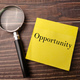 Magnifying glass and sticky note on a wooden background with word Opportunity - PhotoDune Item for Sale