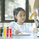preschool girl is interested in laboratory lesson, taking notes on book for her study. - PhotoDune Item for Sale
