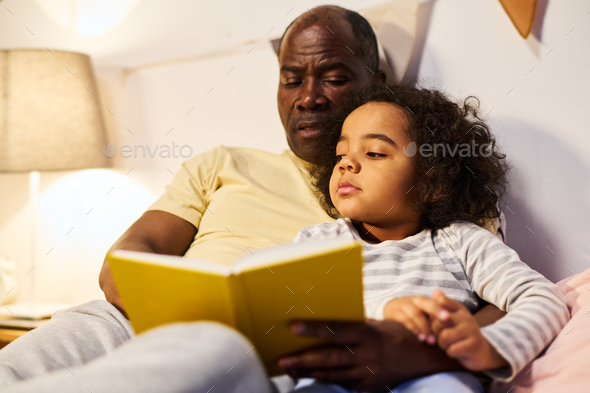 Dad reading book to his son - Stock Photo - Images