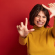 Excited Hispanic female filmmaker showing frame gesture - PhotoDune Item for Sale