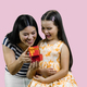 Young brunette mother is opening a red gift box to her happy little princess. - PhotoDune Item for Sale