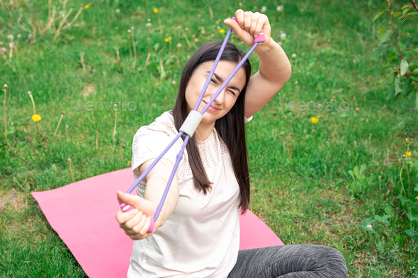 Fitness woman exercising with fitness rubber band outdoors.