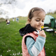 Baby girl sniffs a yellow flower on spring meadow. - PhotoDune Item for Sale