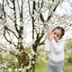 Portrait of preschool girl against white blloming tree in spring. - PhotoDune Item for Sale