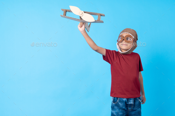 kid in red shirt dream as pilot holding plane paper