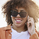 Close up of cheerful black woman in sunglasses and and earphones - PhotoDune Item for Sale