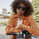 Front view of black woman in sunglasses riding an electric scooter - PhotoDune Item for Sale
