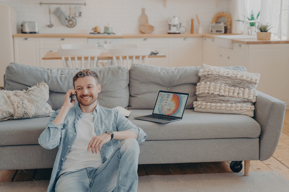Confident male freelance worker calling his employer to tell him good news about project - Stock Photo - Images