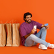 Indian guy shopping online, holding smartphone and bank card - PhotoDune Item for Sale