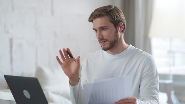 Young Guy Communicates with Colleagues By Video Call Using a Laptop Manager on Remote Work During alt