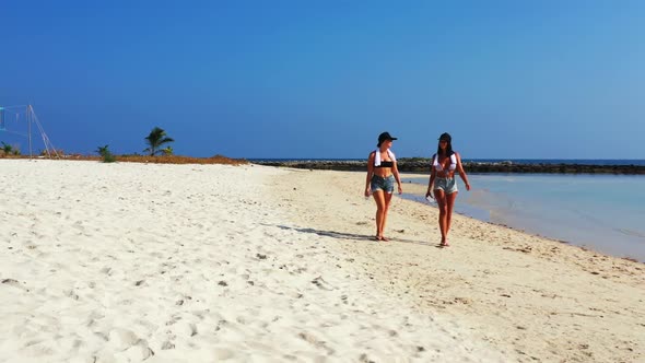 Beautiful ladies enjoying life on exotic shore beach trip by blue ocean with white sandy background  alt