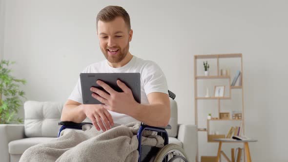 Disabled Man Sitting on Wheelchair and Talking on Video Chat alt