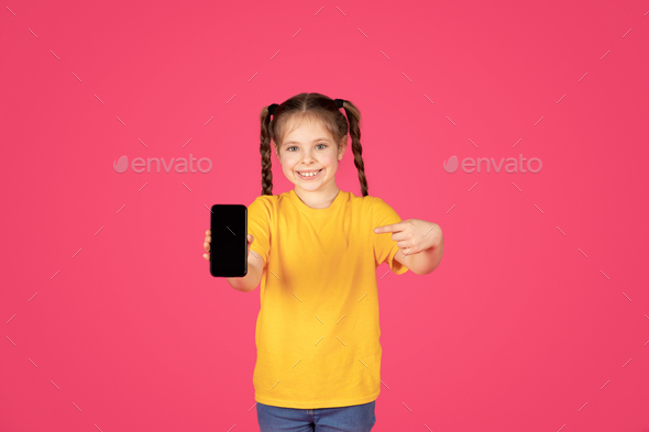 Cute Preteen Girl Pointing At Smartphone With Blank Screen In Hand - Stock Photo - Images