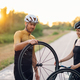 Couple fixing broken wheel or tire on a bike while riding together outside - PhotoDune Item for Sale