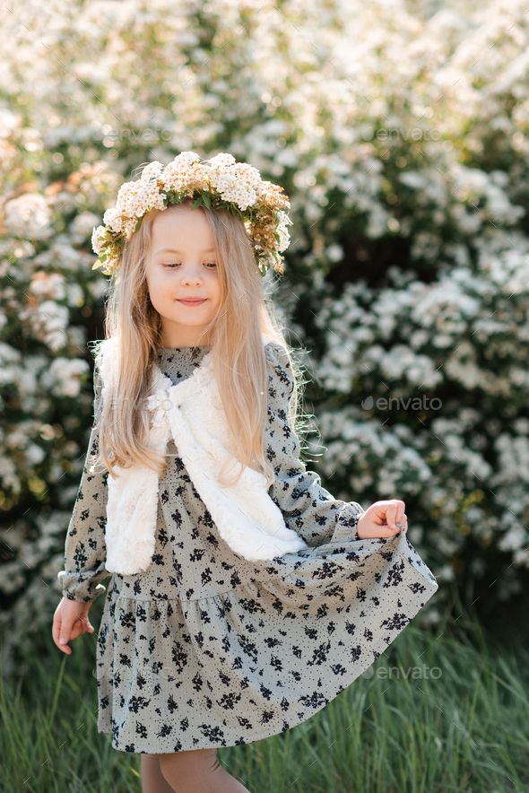 Cute baby girl with flowers in garden outdoor - Stock Photo - Images