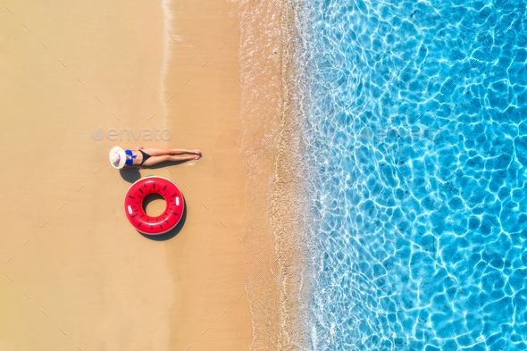 Aerial view of a woman in hat with red swim ring on beach and se - Stock Photo - Images