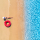 Aerial view of a woman in hat with red swim ring on beach and se - PhotoDune Item for Sale