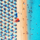 Aerial view of colorful umbrellas on beach, people in blue sea - PhotoDune Item for Sale