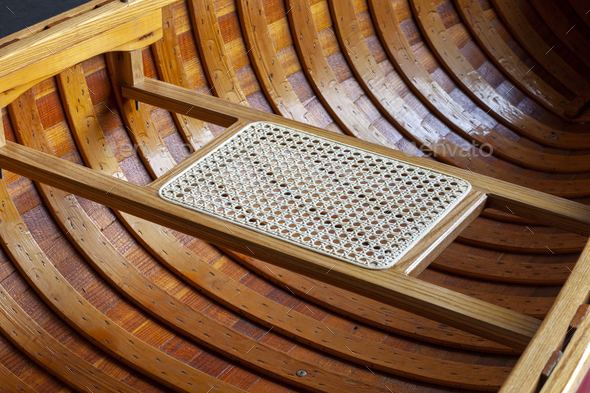 Close up interior shot of a wooden canoe and a caned seat - Stock Photo - Images