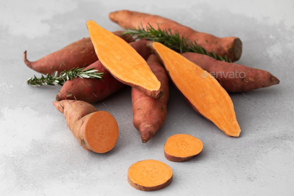 Raw sweet potatoes whole and cut. Orange kumara, sweet potato. Harvesting of root crops. - Stock Photo - Images