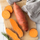 Raw sweet potatoes on cutting board. . Orange kumara, yam. Healthy eating. - PhotoDune Item for Sale