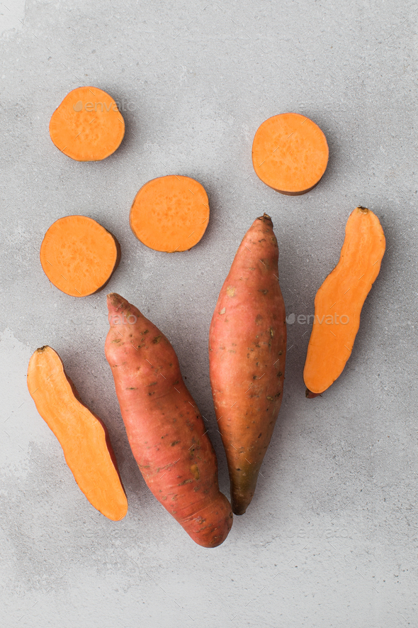 Raw sweet potatoes whole and cut. Orange kumara, sweet potato. Harvesting of root crops. - Stock Photo - Images