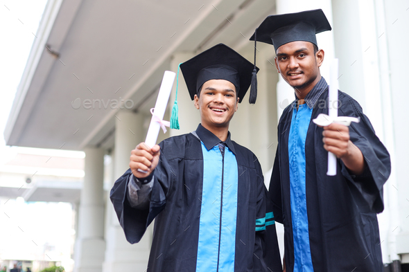 two graduated students men smiling on graduation day - Stock Photo - Images