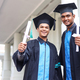 two graduated students men smiling on graduation day - PhotoDune Item for Sale