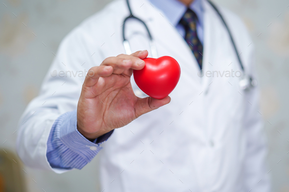 Doctor holding red heart in his hand in hospital.  - Stock Photo - Images