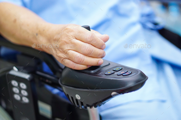Asian senior woman patient on electric wheelchair with remote control. - Stock Photo - Images