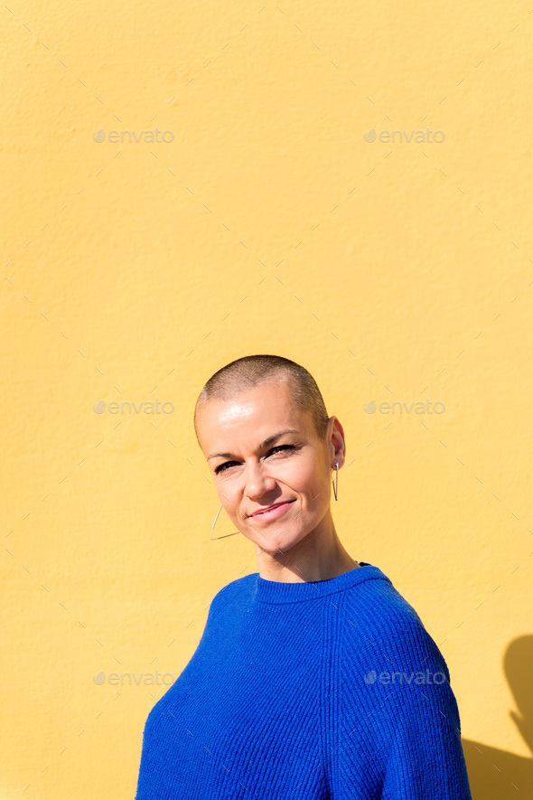 woman with a shaved head smiling looking at camera - Stock Photo - Images