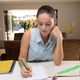 Caucasian teenager girl sitting at table and doing homework - PhotoDune Item for Sale