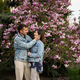 Tender couple in love wear jeans jacket enjoying nice spring day near magnolia blooming tree. - PhotoDune Item for Sale