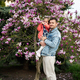  Father with daughter in hands enjoying nice spring day near magnolia blooming tree. - PhotoDune Item for Sale