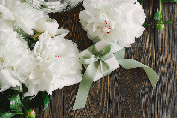 Bouquet of beautiful white peonies with gift boxes on wood background - Stock Photo - Images