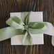 Gift or present box with green ribbon on wood background - PhotoDune Item for Sale