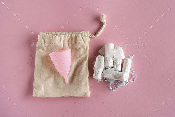 Tampons and menstrual cup on pink background. - Stock Photo - Images