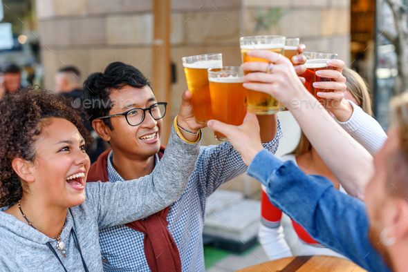 Cheerful diverse friends clinking glasses of beer - Stock Photo - Images