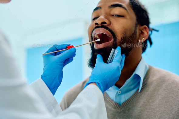 African American man during throat examination at doctor\'s office.