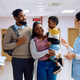 Happy black family talking to a nurse in hallway at doctor&#39;s office. - PhotoDune Item for Sale