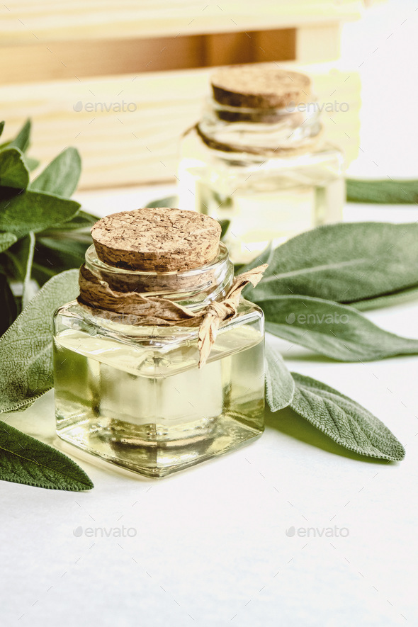 Sage oil in bottles, green sage leaf on white table, copy space - Stock Photo - Images