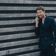 Male corporate worker dressed in formal black suit keeps hand in pocket has telephone conversation - PhotoDune Item for Sale