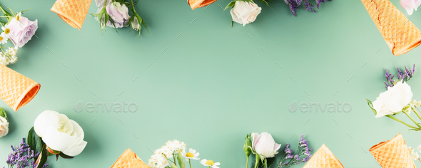 Flat-lay of waffle cones and flowers over pastel green background, top view, flat lay, copy space - Stock Photo - Images