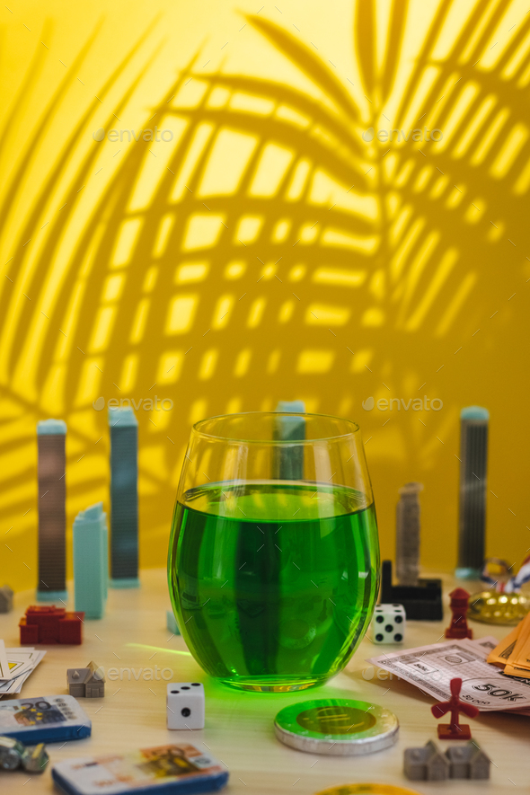  Plastic buildings, playing cards, winner's medal and a glass of green drink