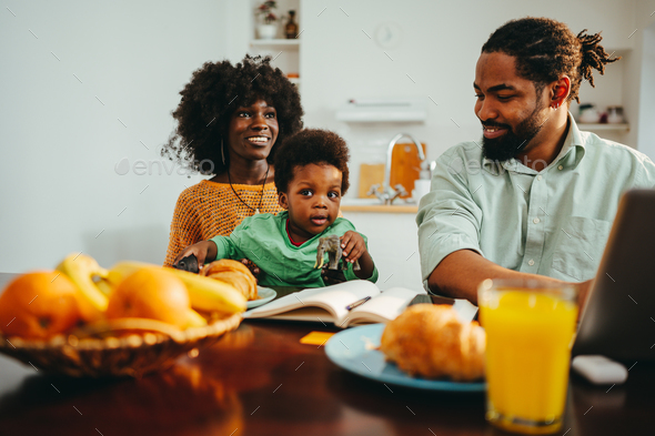 An african american family is sitting at the breakfast table at home in the morning. - Stock Photo - Images