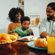 An african american family is sitting at the breakfast table at home in the morning. - PhotoDune Item for Sale