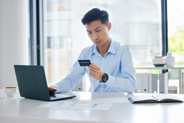 Closeup of one young asian businessman spending money online with a credit card and phone in an off