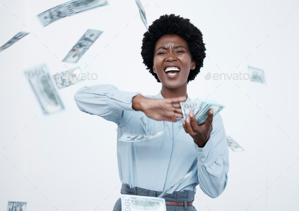 Mature african american businesswoman with an afro looking happy while throwing money around agains