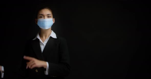 Asian Woman in a Medical Mask Points to the Right Place for Copying on the Right
